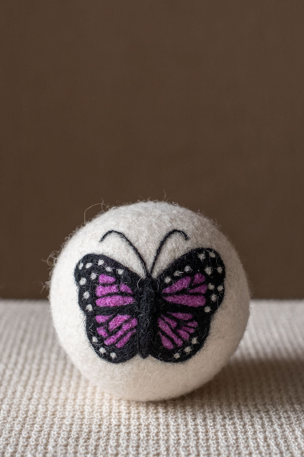 Purple Butterfly wool dryer ball, studio photo