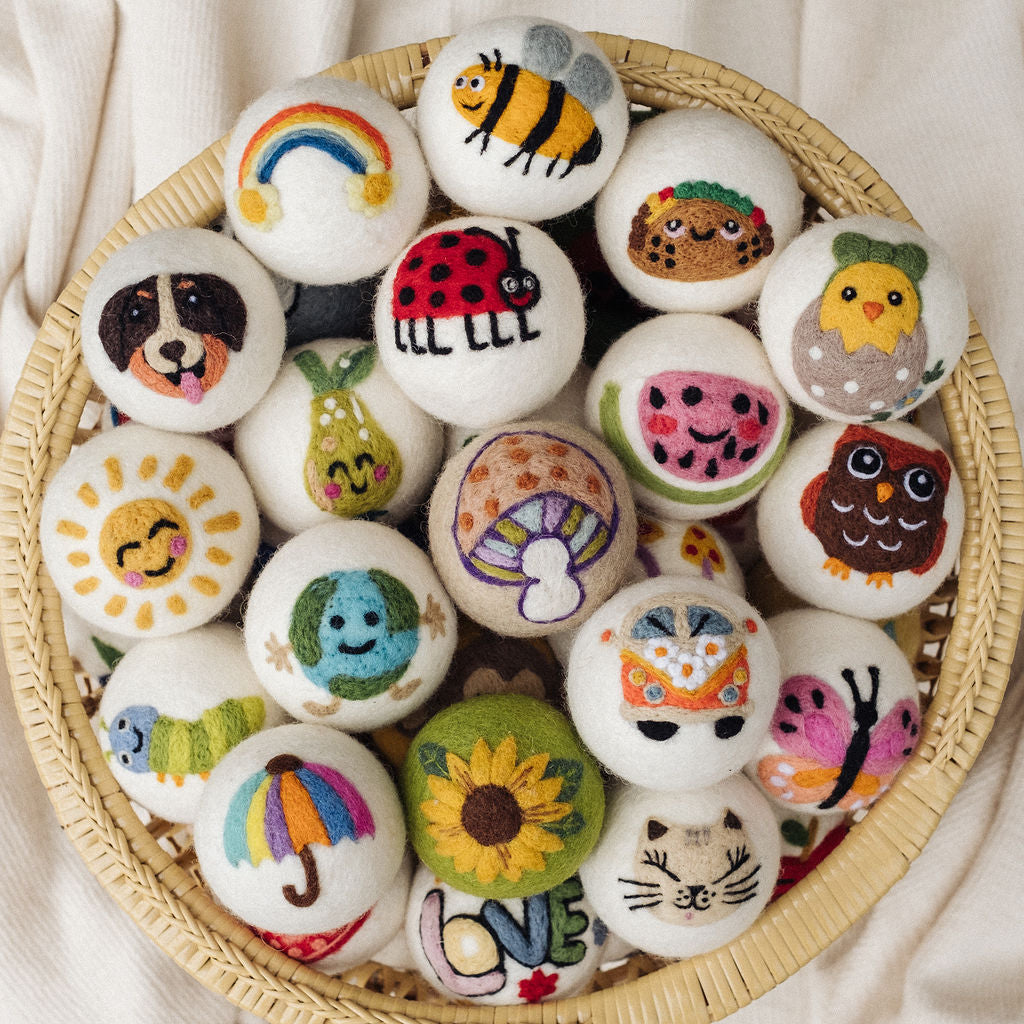 A basket full of hand-felted wool dryer balls in dozens of designs