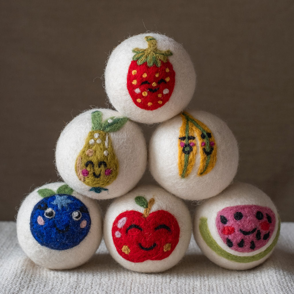 A pyramid of fruit-design wool dryer balls